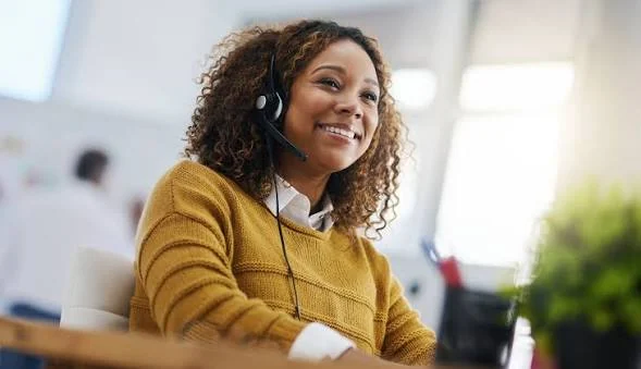 A smiling woman seated at a desk